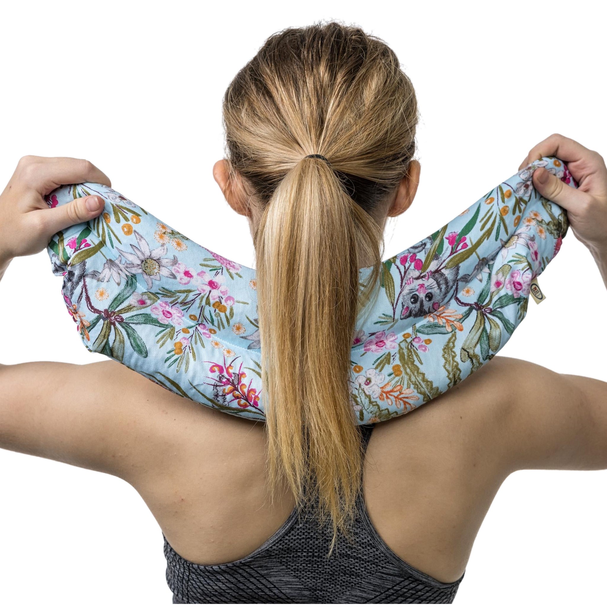 Boomerang neck heat pack held across the shoulders, close up